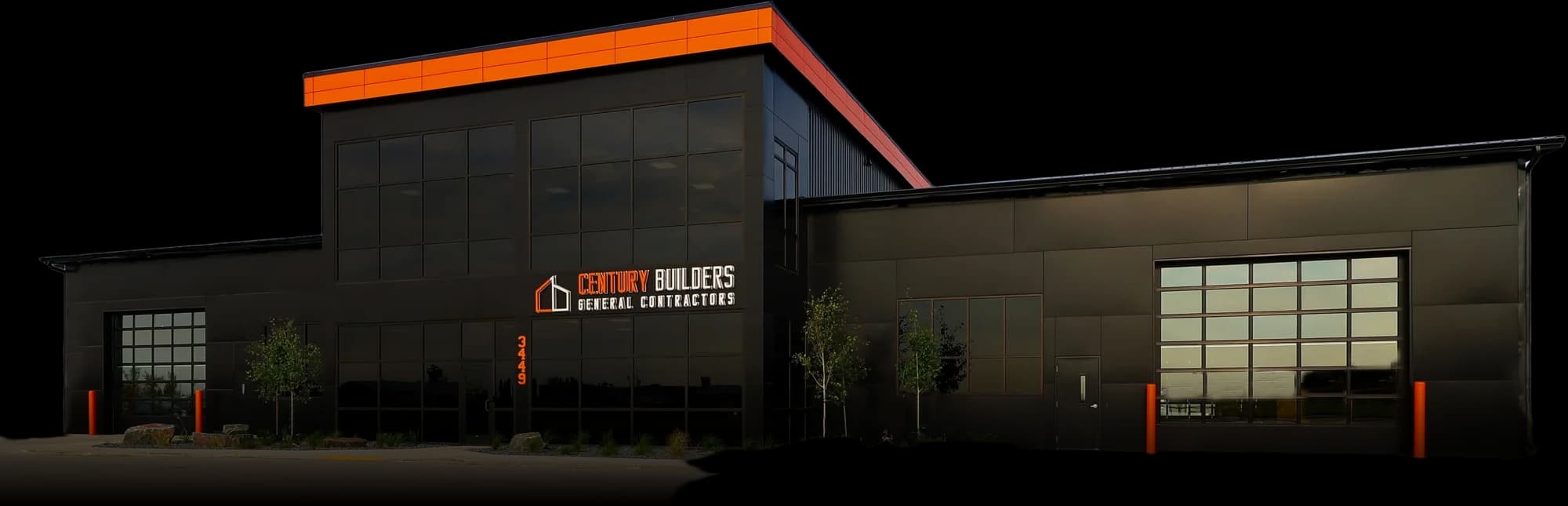 Century Builders headquarters — a black steel building with an orange roofline in Fargo, ND