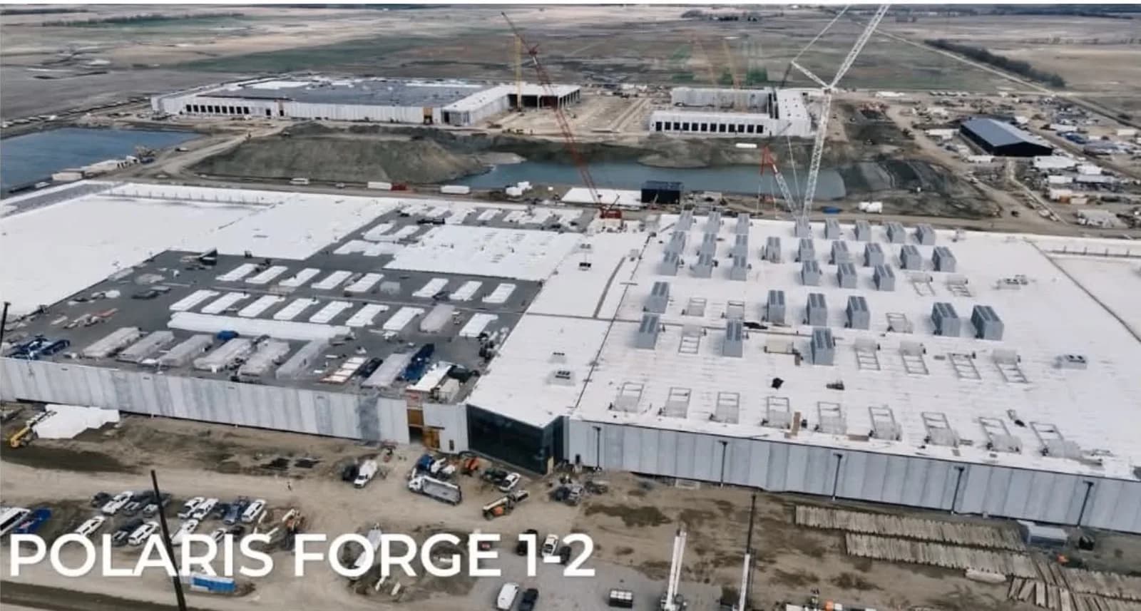 Aerial view of the Polaris Forge 1-2 data center building under construction at Applied Digital's Ellendale, North Dakota campus, with cranes and a second building in the background