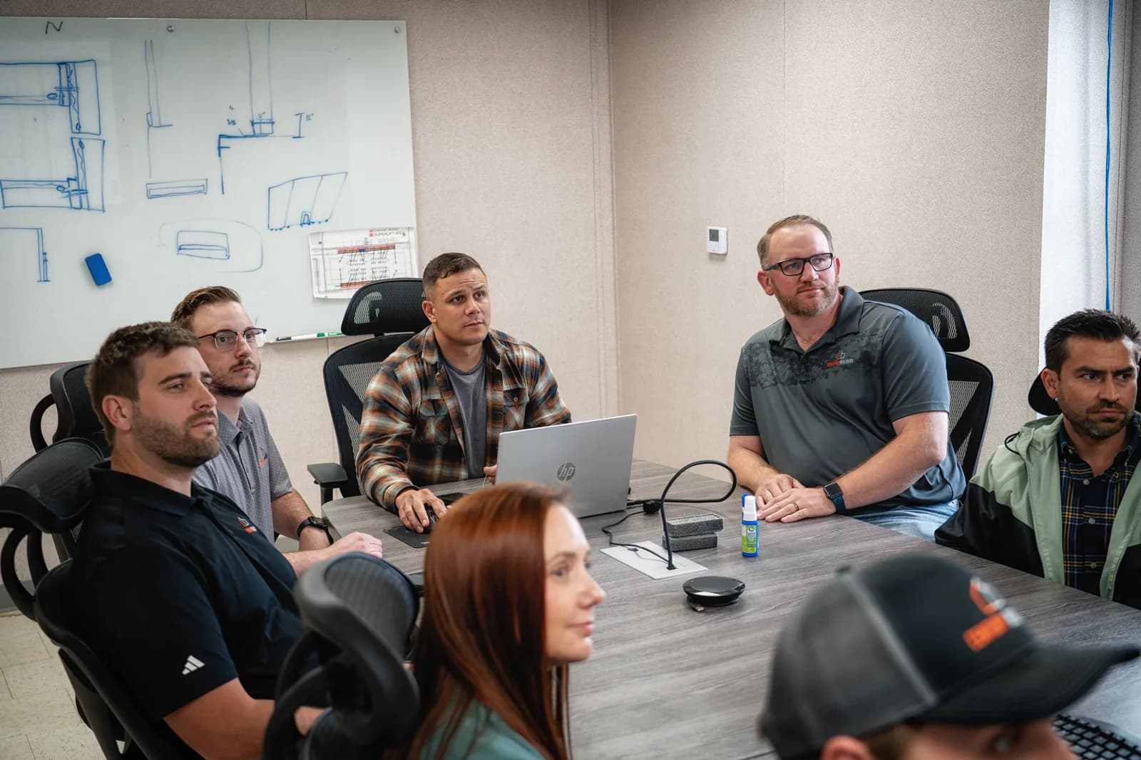 Century Builders team reviewing plans at a whiteboard covered in building sketches